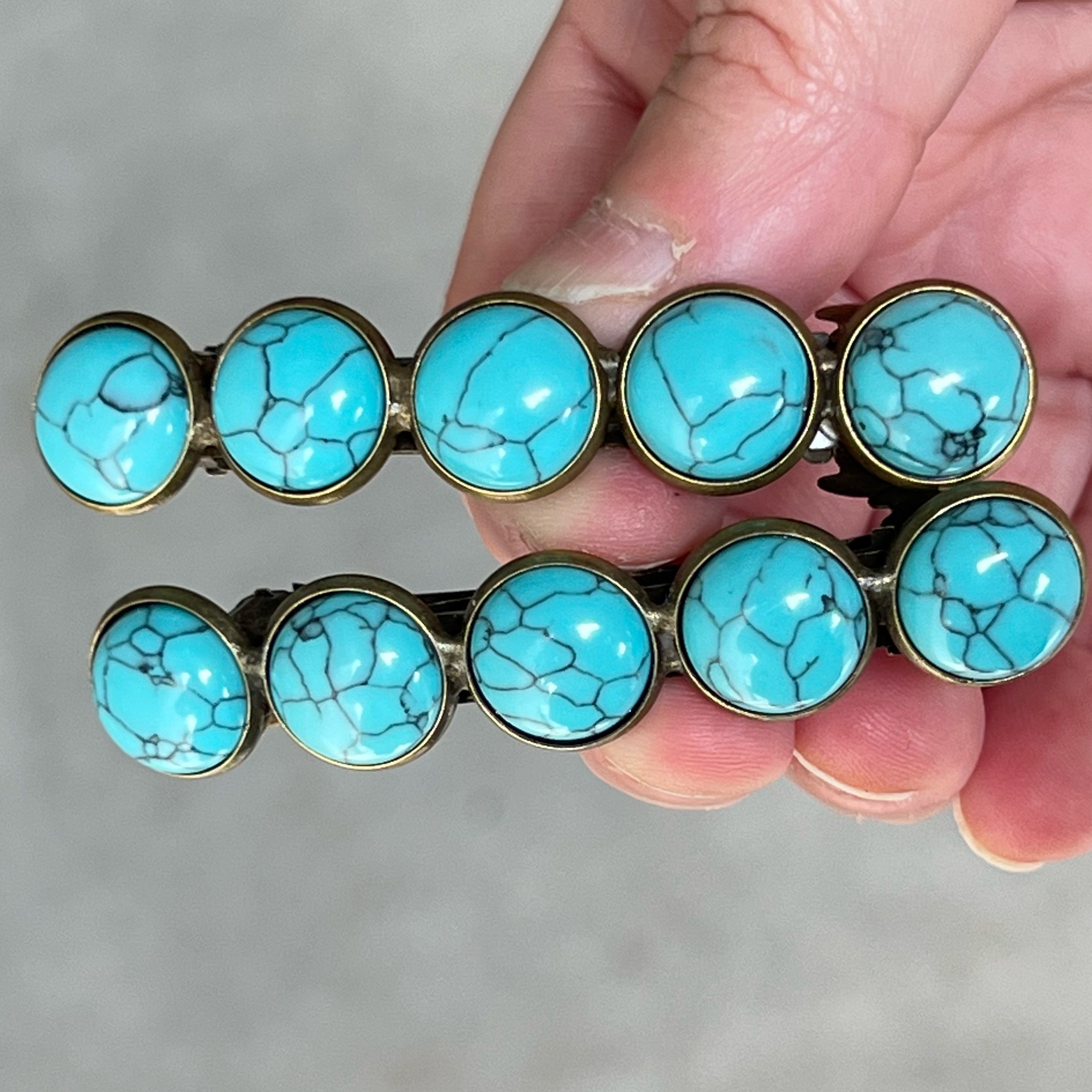 turquoise hair barrettes in hand turquoise hair barrettes in hand